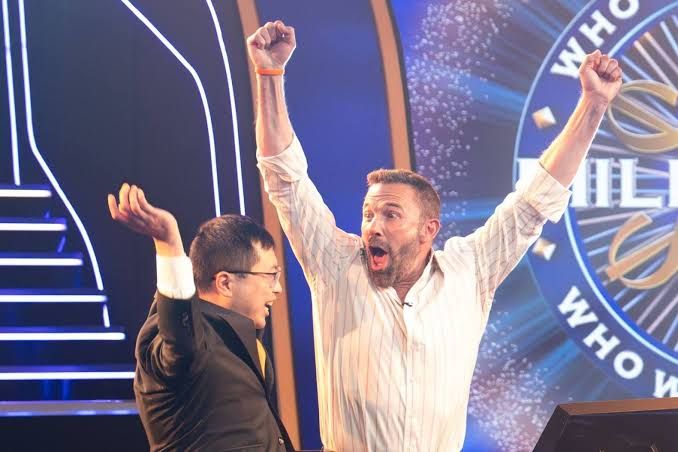 Ben Affleck and Jamie Ding celebrate after winning $1 million on the set of Who Wants to Be a Millionaire.