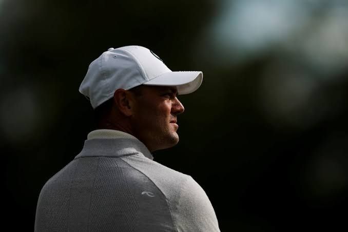 Martin Kaymer standing on a golf course during the LIV Golf tournament speaking to reporters about season cancellations.