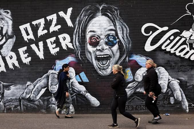 A colorful mural of Ozzy Osbourne painted on a brick wall in Birmingham, England.