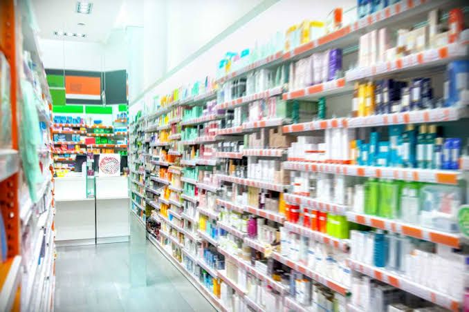 A pharmacy shelf displays various medication bottles and packaging in New York City.