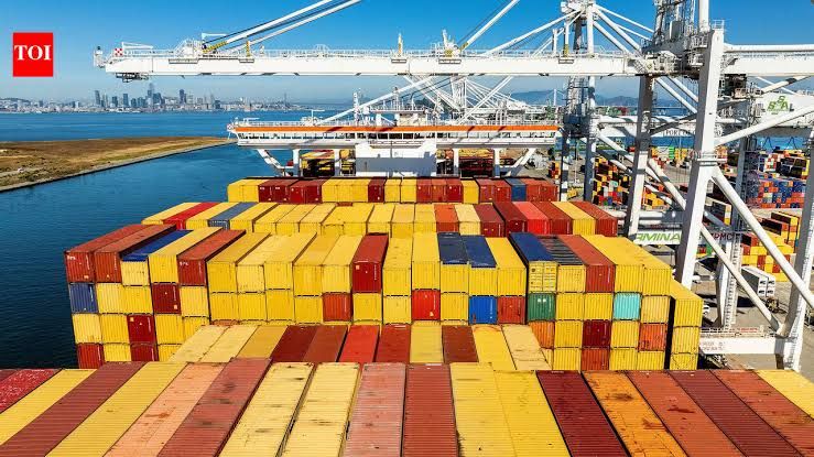A close-up of a shipping container terminal at a US port, symbolizing rising import costs and international trade.
