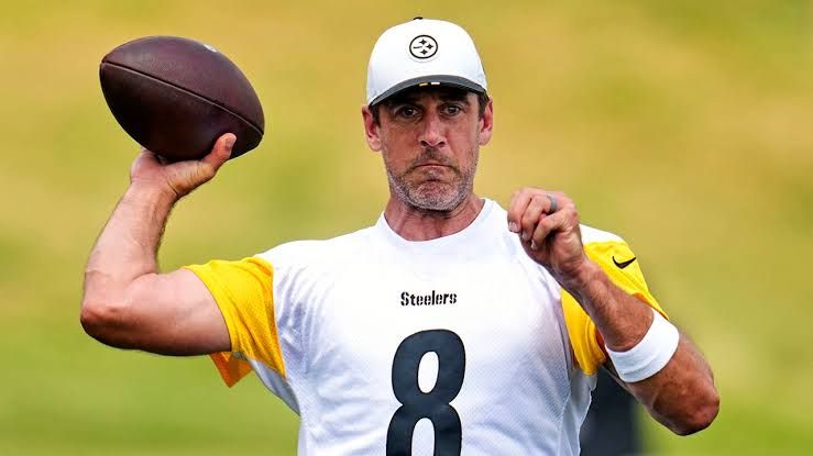 Aaron Rodgers listening to head coach Mike McCarthy during a Pittsburgh Steelers practice session.