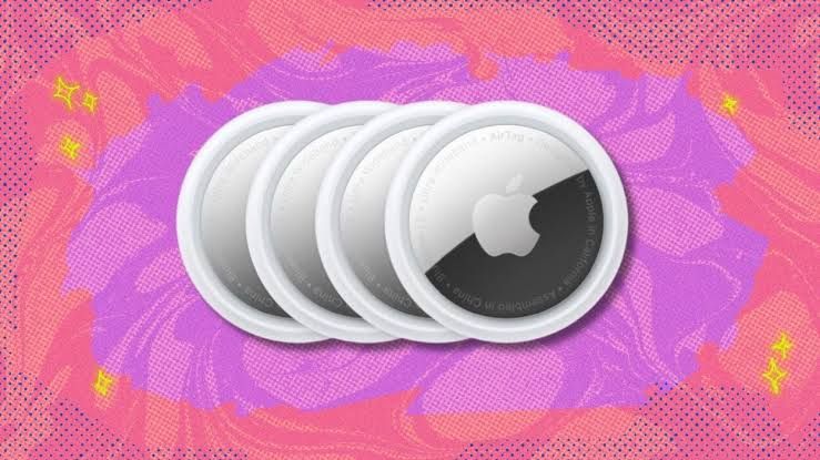 Four Apple AirTags overlapping in a row against a purple and coral background.