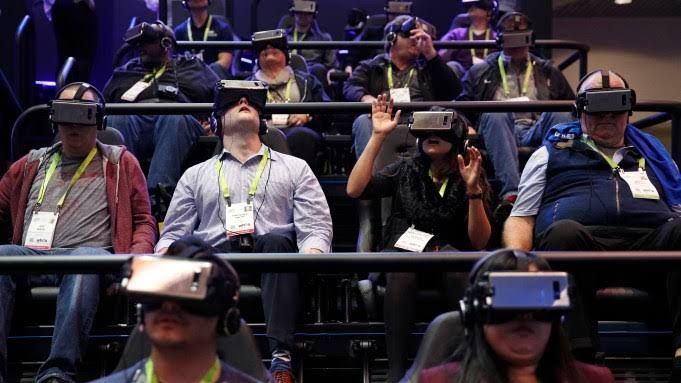 A close-up view of a person wearing a virtual reality headset and hand controllers in an immersive art exhibition.