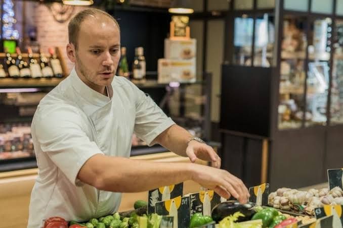 Chef Chris Demaillet arranging fresh produce at a market to illustrate healthy ingredient selection.
