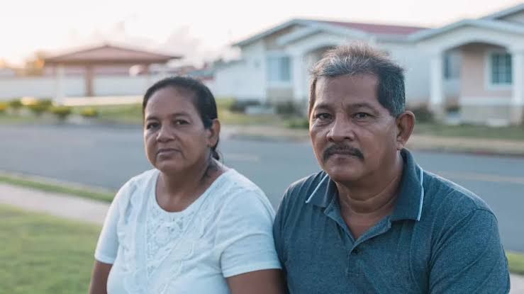 An older couple looking concerned while reviewing financial documents at a table.