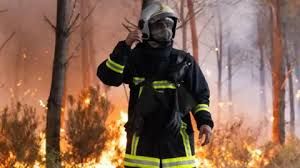 A French firefighter operates a hose against a wildfire in Marcheprime near Bordeaux during the July 2026 emergency.
