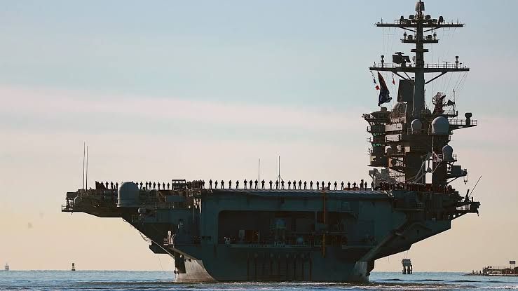 Sailors and Marines stand on the deck of the USS Abraham Lincoln during its 2021 deployment from San Diego.