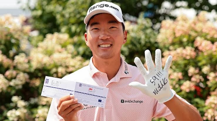 Michael Kim holds his scorecard while celebrating a historic 59-stroke round at the 3M Open at TPC Twin Cities.
