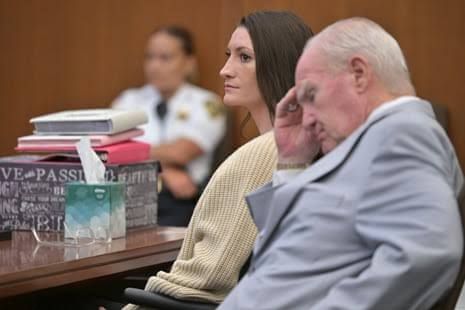 Lindsay Clancy sits at a wooden table in a Plymouth courtroom next to her defense attorney during the ongoing murder trial.