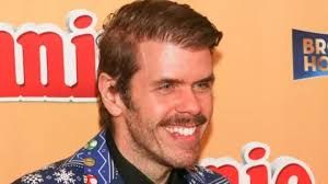 Perez Hilton wearing a blue Super Mario patterned suit while attending an event in Hollywood.