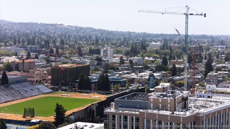Downtown Berkeley street view showing office building construction and local development signage.