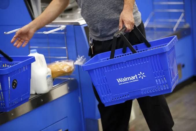 A customer uses a mobile phone to pay at a self-checkout kiosk inside a Walmart retail store.