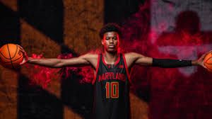 Five-star recruit Baba Oladotun posing in a University of Maryland basketball jersey during his signing announcement.