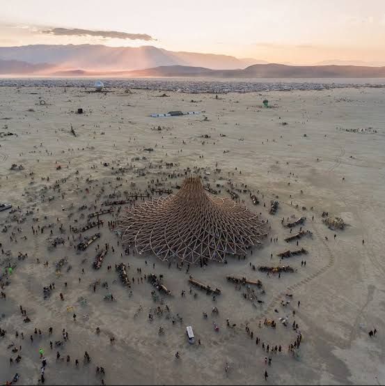 A sprawling view of the Burning Man festival grounds in the Nevada desert featuring large-scale art installations.