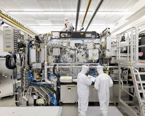 Technicians operate a complex lithography machine inside an ASML facility in the Netherlands.