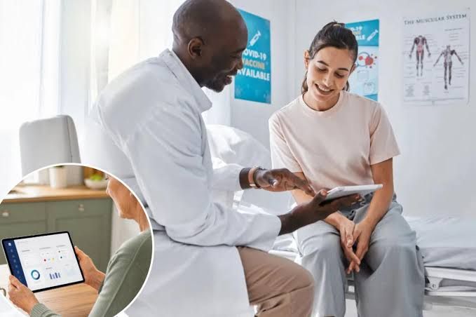 A doctor explaining medical information on a tablet to a patient in a hospital room.