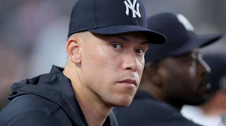 Aaron Judge in his Yankees uniform looking toward the field during a game at Yankee Stadium.
