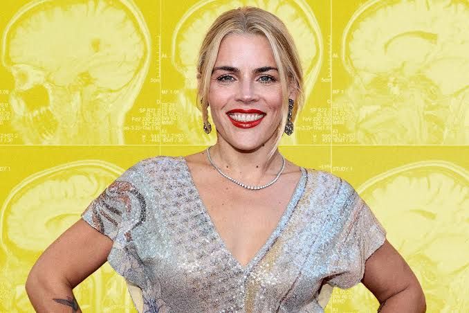 Busy Philipps on the red carpet with a background featuring cheerful yellow brain MRI imagery.