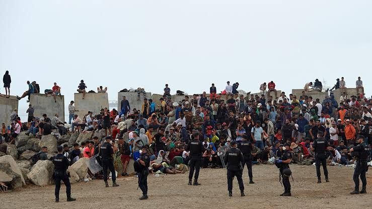 Spanish police monitor a beach area in Ceuta where migrants are gathered following a massive border crossing from Morocco.