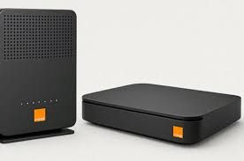Orange branding on electronic equipment being inspected and cleaned for redistribution in an African tech facility.