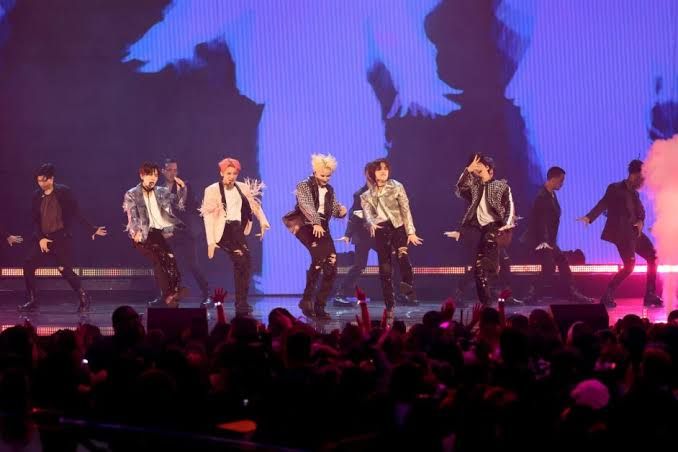 Members of Tomorrow X Together performing on stage at a public event.