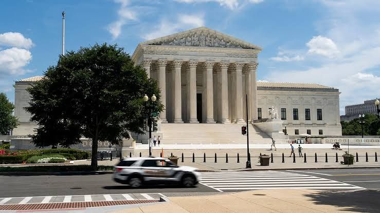 The United States Supreme Court building exterior under a cloudy sky.