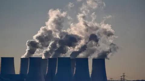 Cooling towers release water vapor at the Jaenschwalde lignite-fired power station in Germany.