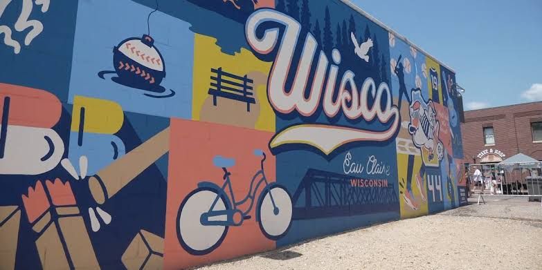 A new Wisco Way mural depicting Wisconsin baseball themes painted on a brick wall along Water Street in Eau Claire.