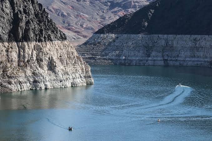Aerial view of the Hoover Dam showing a large white tide line on the rock walls indicating historically low water levels.