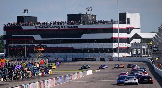A race car speeds under caution flags at World Wide Technology Raceway in Madison, Illinois.