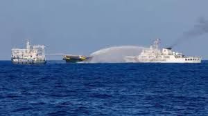 Chinese Coast Guard vessels firing high-pressure water cannons at a smaller Philippine boat at sea.