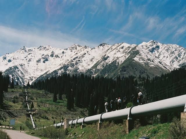A pipeline infrastructure project traversing rugged mountain terrain in Western Canada.