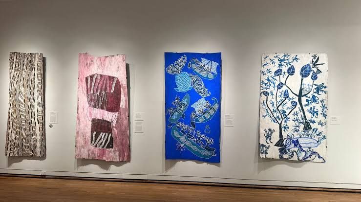 A vibrant Aboriginal desert map painting displayed on a museum wall as part of The Stars We Do Not See exhibition.