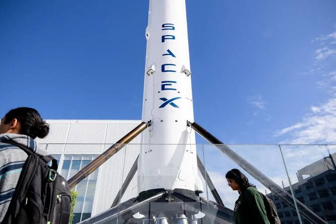 A SpaceX Falcon 9 rocket booster stands outside the company facility in Hawthorne, California.