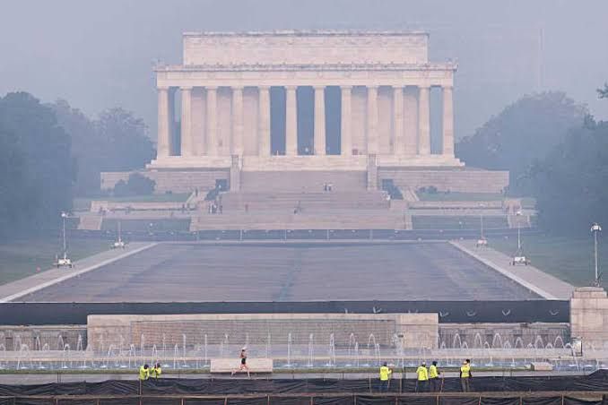A thick, colored haze of wildfire smoke obscures the Lincoln Memorial in Washington D.C.