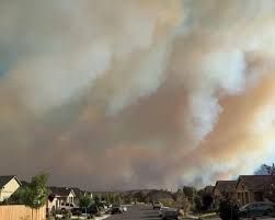 Smoke rises from dry hillsides as emergency helicopters fly over the Hawk fire near Reno, Nevada.