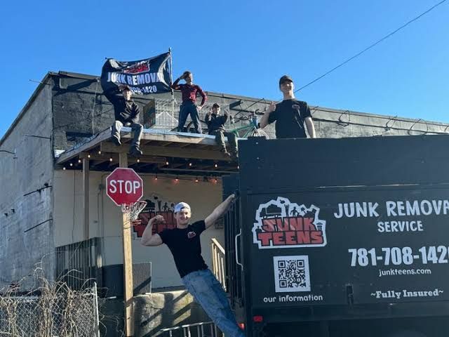 Kirk and Jacob McKinney standing in front of their branded Junk Teens dump truck.