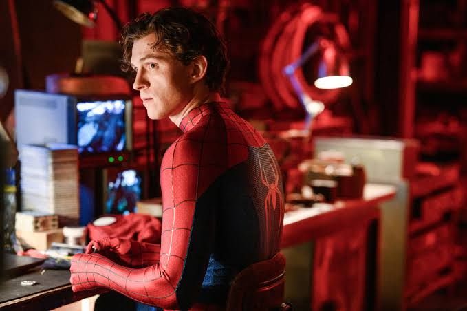 Tom Holland as Spider-Man working at a desk in the film Brand New Day.