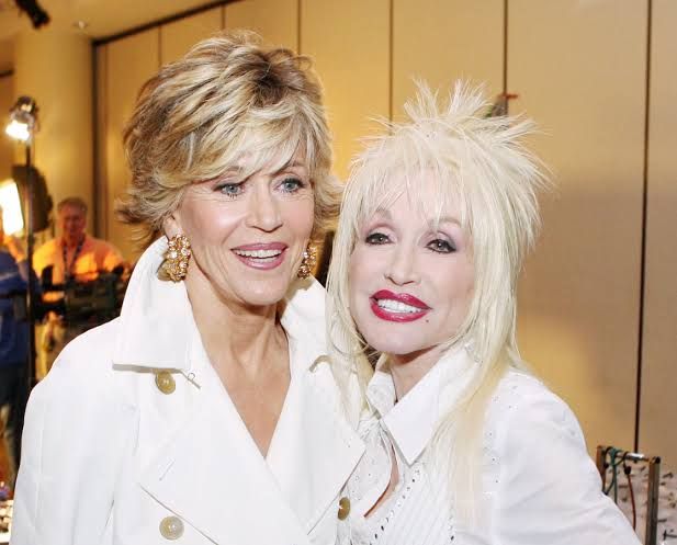 Jane Fonda and Dolly Parton standing together on a film set while filming the 1980 movie 9 to 5.