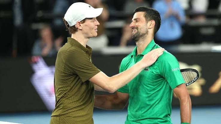 Novak Djokovic and Jannik Sinner standing on a tennis court during a professional match tournament.