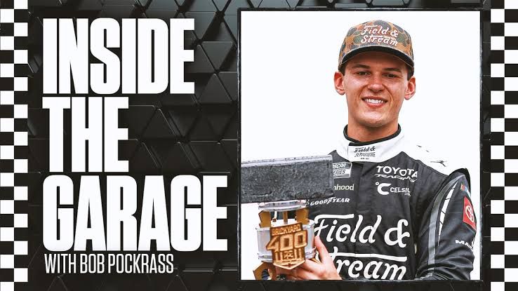 Corey Heim celebrating his Brickyard 400 victory at Indianapolis Motor Speedway while standing near his Toyota race car.