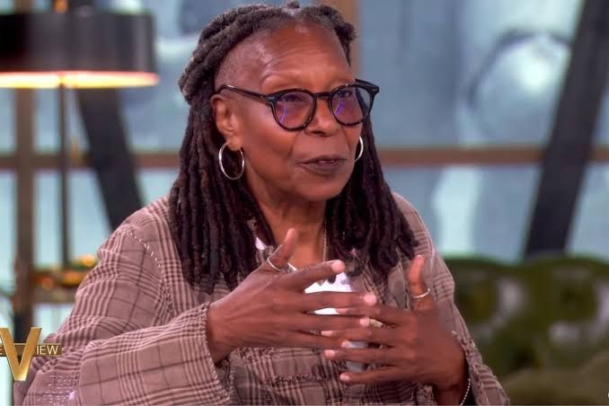Whoopi Goldberg sits at the desk on the set of The View during a live broadcast segment.