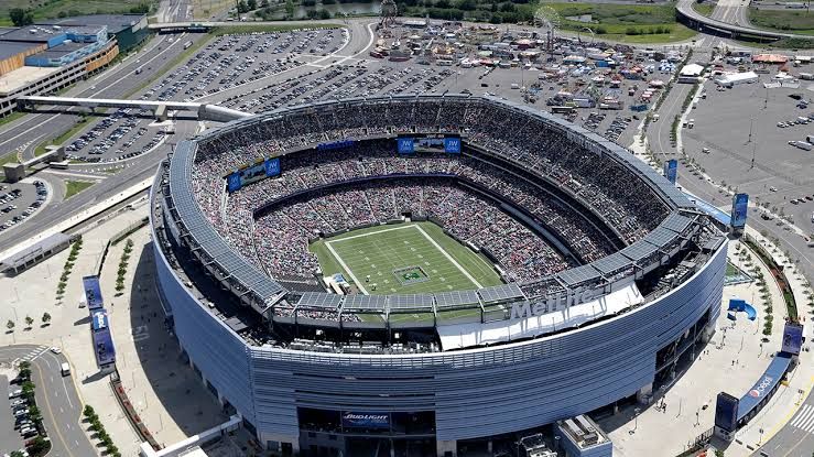 Grounds crew workers install natural grass sod over a stadium pitch in preparation for the 2026 FIFA World Cup.