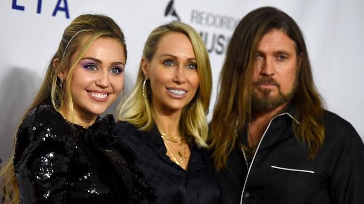 Billy Ray Cyrus attending a country music awards event, appearing in a dark suit.