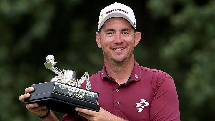 Lucas Herbert holding the trophy after winning the LIV Golf event at JCB Golf and Country Club in Staffordshire.