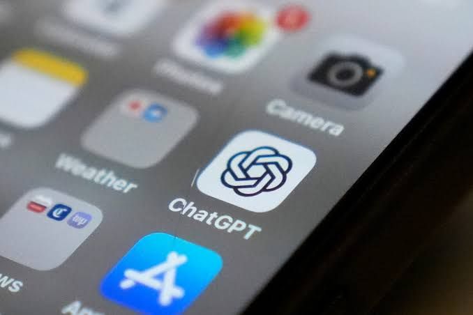 Smartphone screen showing the ChatGPT app icon in a professional setting.