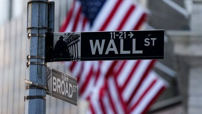 Stock market ticker board showing mixed results for major US indexes after inflation data release.