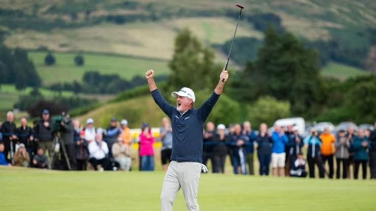 Jerry Kelly holding his putter and celebrating his Senior British Open victory on the 18th green at Gleneagles.