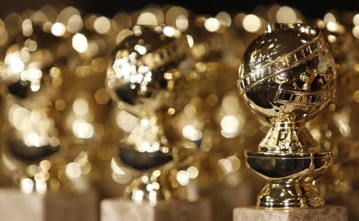 Golden Globe statuettes arranged on a display surface.